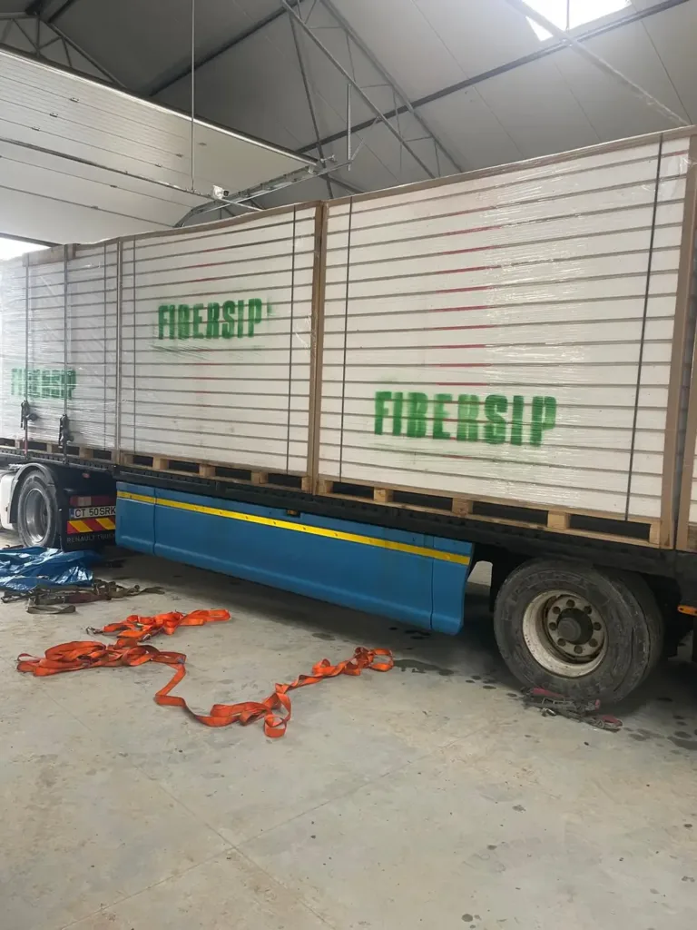 Panouri FIBERSIP transportate pe platformă, ieșind din hala de producție